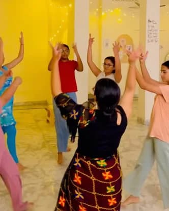 Women learning Garba under fairy lights